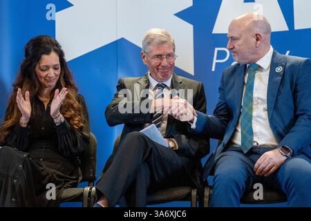 Kenny MacAskill (Mitte) wird von Neale Hanvey (rechts) und Parteivorsitzender Tasmina Ahmed-Sheikh (links) gratuliert, nachdem er als neuer Parteivorsitzender der Alba Party in der Lauriston Hall in Edinburgh bekannt gegeben wurde. Der ehemalige Abgeordnete Kenny MacAskill und MSP Ash Regan kandidierten beide nach dem Tod von Alex Salmond für den Posten des Parteivorsitzenden der Alba. Bilddatum: Mittwoch, 26. März 2025. Stockfoto