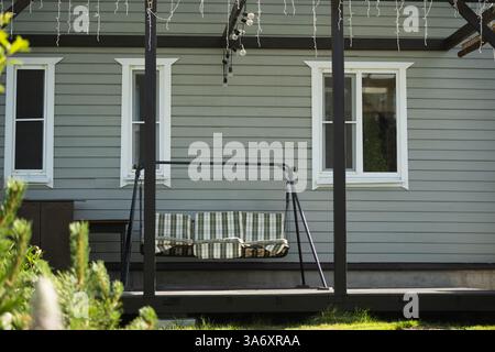 Cottagecore modernes graues Haus mit Terrasse und grünem Gras davor. Sommer. Russische Datscha in der Region Moskau. Im Freien. Hinterhof. Stockfoto