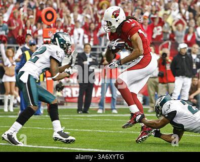 18. Januar 2009: Larry Fitzgerald (11), der Spieler der Arizona Cardinals, springt vor einem Tackle-Versuch von Brian Dawkins, rechts, und bereitet sich darauf vor, den Cornerback Asante Samuel, links, während eines ersten Touchdown-Spiels in der ersten Hälfte der NFC-Meisterschaft im University of Phoenix Stadium in Phoenix, Arizona, am Sonntag, den 18. Januar 2009, zu nehmen. (Eric Mencher/Philadelphia Inquirer/MCT) (Kreditbild: © Eric Mencher/MCT/ZUMAPRESS.com) Stockfoto