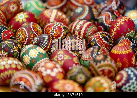 Potsdam, Deutschland. März 2025. Hühnereier mit sorbischer Wachsbatiktechnik liegen auf einem Holzteller am Stand des Lokalgeschichte- und Freilichtmuseums Dissen/Stary Lud im landtag. Quelle: Soeren Stache/dpa/Alamy Live News Stockfoto