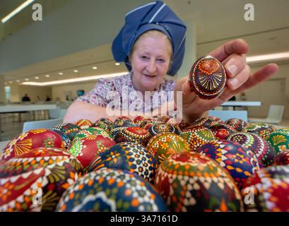 Potsdam, Deutschland. März 2025. Babett Zenker aus dem Heimatmuseum und Freilichtmuseum in Dissen/Stary Lud zeigt im landtag eine Holzplatte mit Hühnereiern, die mit sorbischer Wachsbatiktechnik verziert sind. Quelle: Soeren Stache/dpa/Alamy Live News Stockfoto