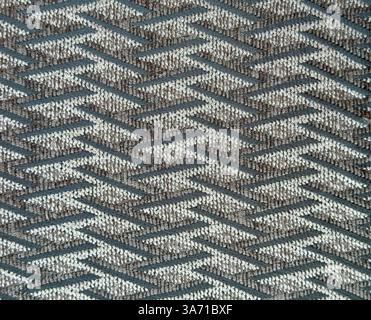 Nahaufnahme von blauem und grauem Gewebe im Webfadenmuster. Dunkelblaues graubeiges Textilgewebe mit Chevron-Gewebe, nahtlose Hintergrundstruktur. Stockfoto