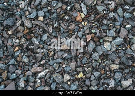 Graue, kleine Steine, Bodenstruktur. Schwarzer kleiner Straßenstein Hintergrund. Stockfoto