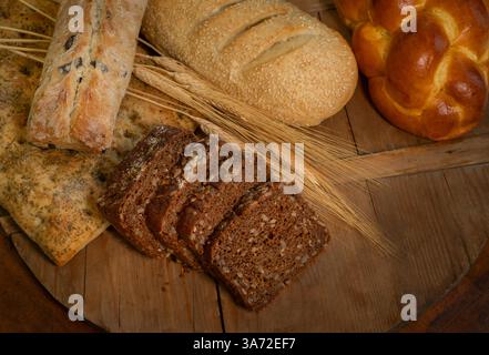 Blick von oben auf verschiedene Brotsorten auf hölzernem Schneidebrett Stockfoto