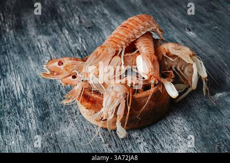 Eine hölzerne Schüssel mit Squilla Mantis, einer Art von Mantis Shrimps, die auf spanisch als galeras bekannt ist, auf einem grauen Holztisch Stockfoto