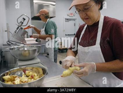 7. Oktober 2014 - Hillsborough, NC, USA - Debbie Donnald, rechts, Trims Waschen Babyginger zum eventuellen Hacken als Geschäftspartner Audrey Lin, links, füttert gewaschene, getrimmte ganze Karotten in einen Gemüsevernichter 7. Oktober 2014 auf der Two Chicks Farm Farm in Orange County, N.C. und seit 2010 betreiben sie ihr Gärgeschäft, das gesunde probiotisch fermentierte Gemüseprodukte wie Sauerkraut sowie Kimchi und Pfeffergelees herstellt Stockfoto