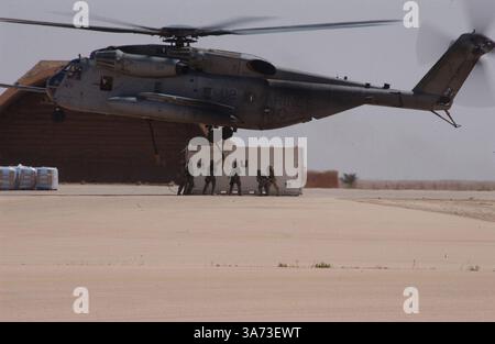 20. April 2004; Al Asad, Irak; Ein Helicopter Support Team der Marine Wing Support Squadron 273, derzeit am 3. Marine Aircraft Wing Wing Wing Wing befestigt, hakt Ketten von einer externen Ladung an einen CH-53E Super Hengst in Al Asad, Irak, 20. April. Der Hubschrauber und die Besatzung gehören zur Marine Heavy Helicopter Squadron 465, Marine Aircraft Group 16, 3rd Marine Aircraft Wing. Die HMH-465 und ihre Schwestergeschwader HMH-466 stellen Schwerlastkapazitäten für alle im Westirak operierenden Marine-Einheiten bereit. Stockfoto