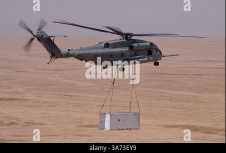 20. April 2004; Westirak, Irak; Ein CH-53E Super Hengst der Marine Heavy Helicopter Squadron 465, Marine Aircraft Group 16, 3rd Marine Aircraft Wing, hebt am 20. April eine externe Frachtladung zu einem Vorwärtsflugplatz im Westirak. Der Hubschrauber verwendete ein Dual Point Hook System, um die Last stabil zu halten und den Hubschrauber vor dem Schwingen der Last während des Fluges zu schützen. Stockfoto