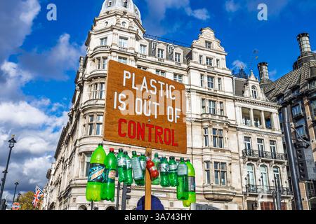 Der Aktivist hält ein Anti-Plastik-Verschmutzungsschild mit Flaschen im städtischen Straßenprotest Stockfoto