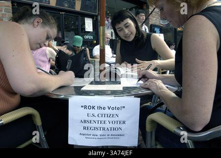 August 2004; Seoul, SÜDKOREA; CHRISTINA DELGADO, 24 von Minneapolis Minnesota, Mitte, hilft den USA Die Bürger müssen das fehlende Stimmzettel für die bevorstehenden US-Präsidentschaftswahlen in Seoul Korea am Sonntag, den 29. August 2004, ausfüllen. Etwa 100.000 US-Bürger leben in Südkorea, einschließlich US-Militärs. Stockfoto