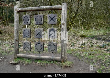 Ein großes hölzernes Nullen- und Kreuzspiel in einem Waldgebiet. Stockfoto