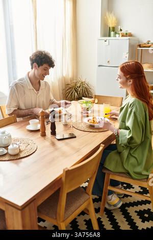 Ein junges Paar teilt sich ein köstliches Frühstück und feiert ihre Verbundenheit in einem warmen Zuhause. Stockfoto