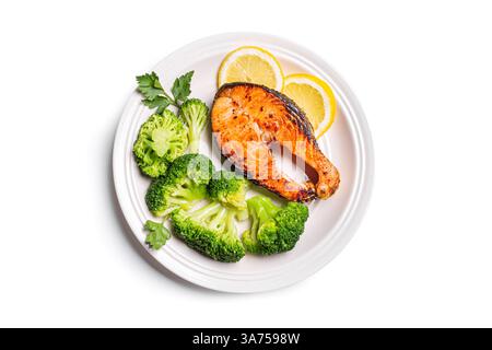 Gebratenes Lachsfischsteak mit gedämpftem Brokkoli-Gemüse und Zitrone auf Teller isoliert auf weißem Hintergrund, Blick von oben. Gesundes ausgewogenes Lebensmittelkonzept, k Stockfoto