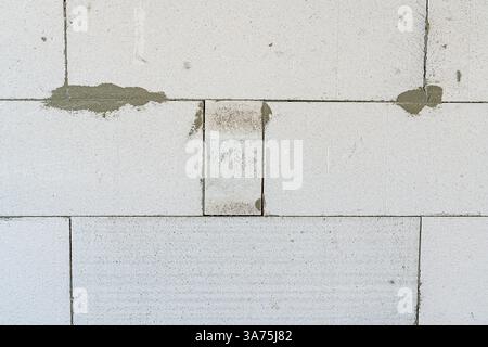 Hintergrund einer Wand aus weißem Porenbeton, Nahaufnahme. Stockfoto