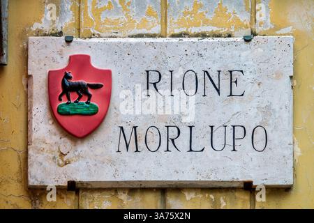 Die Marmortafel von Rione Morlupo in Foligno, Umbrien, Italien, zeigt einen schwarzen Wolf auf rosa Hintergrund. Stockfoto