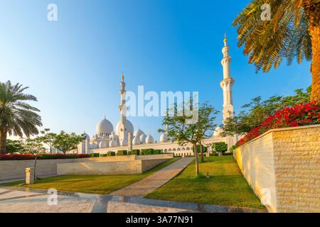 Blick auf die Scheich-Zayed-Moschee, die größte Moschee in den VAE, von einem Gartenbereich in Abu Dhabi, Vereinigte Arabische Emirate. Stockfoto