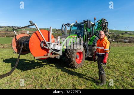 Der Landwirt verteilt Gülle mit einem Nabelpumpensystem und einem Dribble Bar. Drinagh, West Cork, Irland. Stockfoto