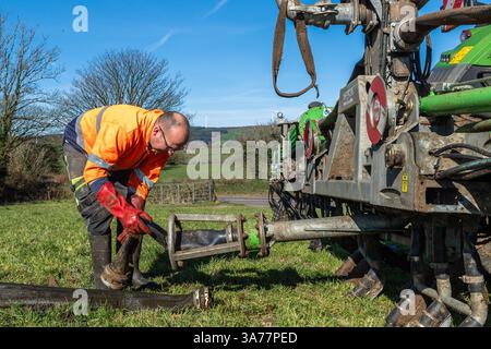 Der Landwirt verteilt Gülle mit einem Nabelpumpensystem und einem Dribble Bar. Drinagh, West Cork, Irland. Stockfoto