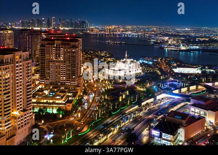 Blick auf eine beleuchtete Scheich-Hamad-bin-Jassim-Moschee auf Pearl Island, mit Blick auf die Skyline der Innenstadt im Hintergrund in Doha Qatar. Stockfoto