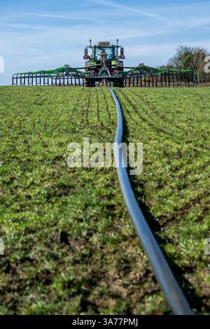 Der Landwirt verteilt Gülle mit einem Nabelpumpensystem und einem Dribble Bar. Drinagh, West Cork, Irland. Stockfoto