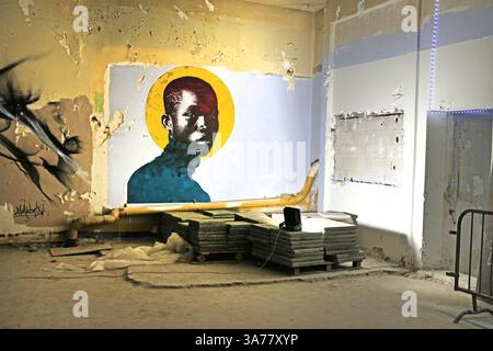 Anonymes Fresko, das das Gesicht eines schwarzen Mannes auf goldenem Hintergrund darstellt. Eröffnung der freien Street Art Ausstellung „l'Expo des 150 - Cabaret du Chat Noir“ vom 25. Bis 30. März 2025 in einer alten Telefonzentrale im 9. Arrondissement von Paris in seinem rohen Zustand. Die 3. Ausgabe dieser Veranstaltung, die Urban Art Artists Carte Blanche gibt: Kein festgelegtes Thema und eine sehr offene Szene. Stockfoto