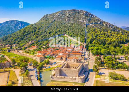 Aus der Vogelperspektive von Ston, Kroatien, mit den beeindruckenden Ston Mauern, einer der längsten Befestigungsanlagen in Europa, die sich durch die üppige Landschaft schlängelt Stockfoto