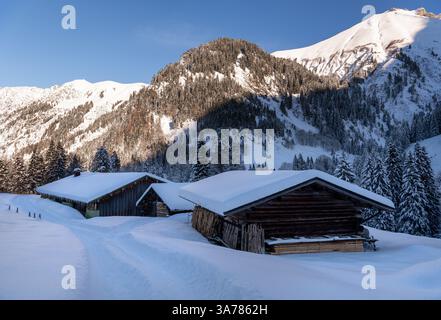 Tief verschneite Berghütten in den Bayerischen Alpen an einem sonnigen Dezembertag Stockfoto