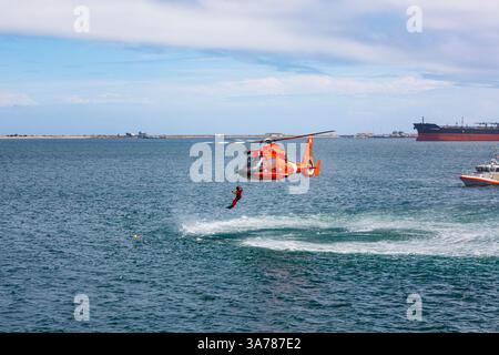 Der Hubschrauber der US-Küstenwache schwebt über dem Wasser in einer Demonstration einer Rettung für einen Meeresschwimmer. Stockfoto