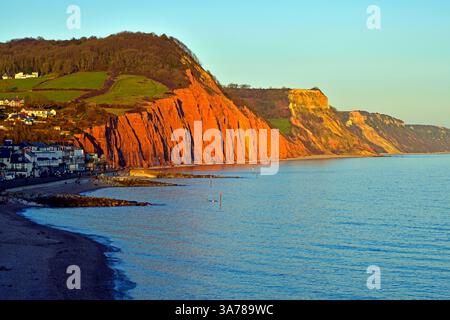 Die Sandsteinklippen von Sidmouth im Abendlicht ragen vom blauen Wasser der Lyme Bay an der Jurassic Coast in Südengland ab. Stockfoto