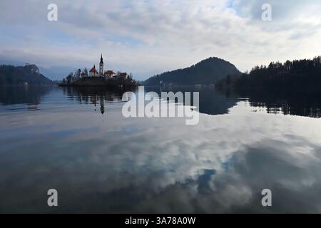 Malerischer Blick auf die Insel Bleder See und die Kirche der Mutter Gottes mit Reflexionen auf dem ruhigen See, Bled, Slowenien Stockfoto