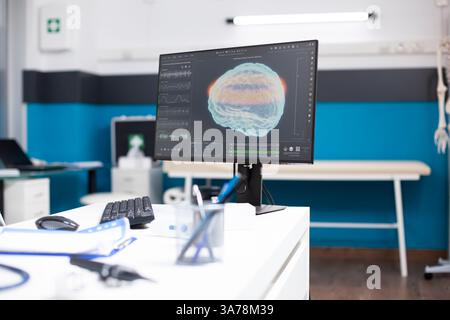 Medizinisches Büro ohne Personal hat Computermonitor, der Gehirnschaden-Analyse-Deal anzeigt, für die Gesundheitsdiagnostik. Der Krankenhausraum ist mit Akten und modernen Arztwerkzeugen organisiert. Stockfoto