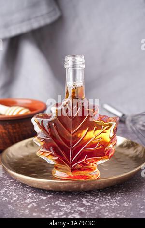 Flasche leckerer Ahornsirup auf dem Tisch Stockfoto
