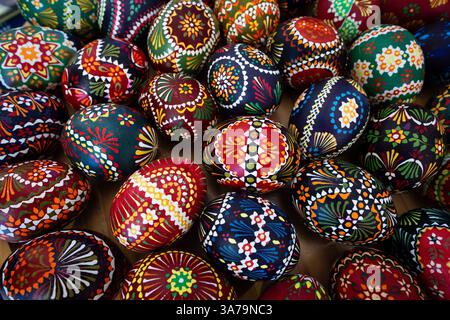 Potsdam, Deutschland. März 2025. Hühnereier mit sorbischer Wachsbatiktechnik liegen auf einem Holzteller am Stand des Lokalgeschichte- und Freilichtmuseums Dissen/Stary Lud im landtag. Quelle: Soeren Stache/dpa/Alamy Live News Stockfoto
