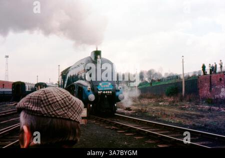 Original-35-mm-Diafilm aus den 1960er Jahren mit der legendären LNER-Klasse A4-Dampflokomotive Nr. 4498 „Sir Nigel Gresley“. Die Bilder, die während eines Eisenbahnereignisses aufgenommen wurden, zeigen die stromlinienförmige blaue Lokomotive, umgeben von Dampf, Zuschauern und Vintage-Wagen, die an das goldene Zeitalter der britischen Dampfeisenbahnen erinnern. Stockfoto