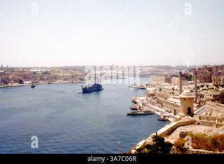 Originalbild aus den 1960er Jahren auf 35-mm-Diafilm, das das historische Fort St. Angelo und den umliegenden Grand Harbour in Valletta, Malta, zeigt. Auf dem Foto sehen Sie einen arbeitenden Hafen, der von Händlern und Marineschiffen wimmelt, die alten Steinmauern von Birgu und einen Panoramablick über den Hafeneingang. Stockfoto