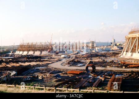 Dieses Originalfoto, das im April 1969 aufgenommen wurde, zeigt die Baustelle des Ferrybridge Power Station C in West Yorkshire, England. Das Bild erfasst die frühen Stadien dieser großen industriellen Entwicklung, mit Gerüsten, Kränen und großen runden Betonsockeln im Blick. Stahlstäbe und Baumaterialien sind über den schlammigen Standort verstreut, was den Umfang und die Komplexität des Projekts während der britischen Energieinfrastruktur unterstreicht. Stockfoto