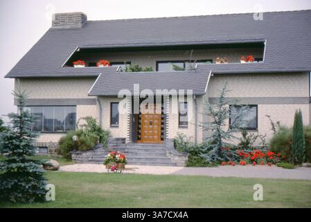 Ein modernes Einfamilienhaus in Sievershausen, fotografiert im Juli 1979. Das Haus verfügt über helle Ziegelsteine, eine geometrische hölzerne Haustür und ein steiles Schieferdach mit Dachfenstern Stockfoto