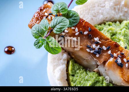Kabeljaufilet mit Spinat- und Brokkoli-Püree und Blumenkohl auf einer blauen Platte. Das Konzept der gesunden und diätetischen Ernährung. Das Restaurant serviert das di Stockfoto