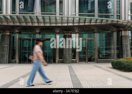Hongkong, China. März 2025. Eine Person läuft am Cheung Kong Centre vorbei, dem Hauptquartier von CK Hutchison Holdings in Hongkong. Am 26. März 2025 verstärkte Peking den Druck auf CK Hutchison wegen des Verkaufs von 23 Milliarden Dollar an Hafenanlagen im Panamakanal und warnte staatliche Firmen, die Geschäfte mit Li Ka-shing's Geschäftsimperium einzustellen. Trotz der Spannungen plant CK Hutchison, die Vereinbarung bis zum 2. April abzuschließen, wodurch die Kontrolle über die wichtigsten maritimen Infrastrukturen verlagert und geopolitische Bedenken angeheizt werden. Quelle: SOPA Images Limited/Alamy Live News Stockfoto