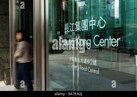 Hongkong, China. März 2025. Eine Person geht aus dem Cheung Kong Centre, dem Hauptquartier von CK Hutchison Holdings, in Hongkong. Am 26. März 2025 verstärkte Peking den Druck auf CK Hutchison wegen des Verkaufs von 23 Milliarden Dollar an Hafenanlagen im Panamakanal und warnte staatliche Firmen, die Geschäfte mit Li Ka-shing's Geschäftsimperium einzustellen. Trotz der Spannungen plant CK Hutchison, die Vereinbarung bis zum 2. April abzuschließen, wodurch die Kontrolle über die wichtigsten maritimen Infrastrukturen verlagert und geopolitische Bedenken angeheizt werden. Quelle: SOPA Images Limited/Alamy Live News Stockfoto