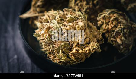 Trockener CBD-Cannabis, auch bekannt als getrocknete Hanfblumen auf einem Holztisch Stockfoto