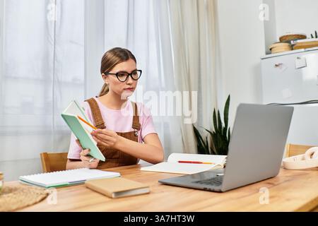 Eine schöne junge Frau, die in ihrem stilvollen Haus an einem Holztisch saß. Stockfoto