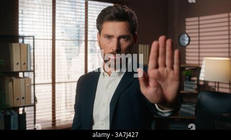 Selbstbewusster ernsthafter Kaukasier männlicher Kerl Geschäftsmann Geschäftsmann Geschäftsleiter Chef Firma CEO im Büro Blick auf die Kamera Hand in Front Stop Geste Stockfoto