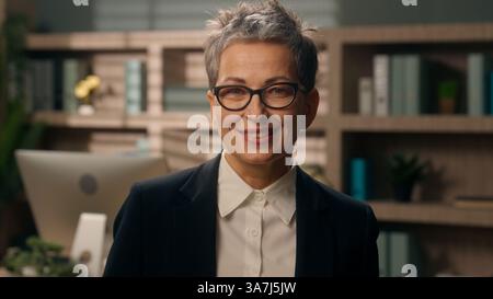 Fröhlich lächelndes selbstbewusstes Porträt in Büroerfolg Geschäft Weiße Seniorin Geschäftsfrau mittleren Alters Reife Arbeitgeberin Unternehmerin Stockfoto