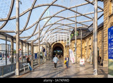 Personen in der gläsernen Fahrgasthalle des luxemburgischen Bahnhofs in Luxemburg-Stadt als Erweiterung der Fassade des Personengebäudes. Stockfoto