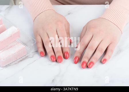 Nahaufnahme weiblicher Hände mit modischer rosafarbener Maniküre auf Nägeln. Kopierbereich. Stockfoto