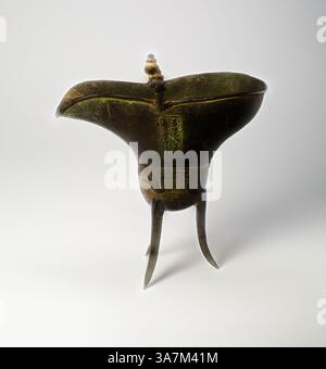 Ein kunstvoll verziertes Gefäß im antiken Stil mit einer einzigartigen geschwungenen Form, mit komplizierten Gravuren und auf schlanken Beinen stehend. Das Design hebt die kulturelle Handwerkskunst und historische Bedeutung hervor. Klassische Kunst mit modernem Touch neu interpretiert von Artotop, Goblet (jue), Ming-Dynastie, Tianshun-Zeit (1457–1464), 1464, China, Bronze Stockfoto