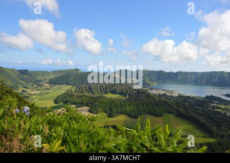 Wandern rund um den Krater von Sete Cidades auf der Insel São Miguel auf den Azoren mit einem wunderschönen grünen Blick und Hortensie Blumen und einem blauen Himmel Stockfoto