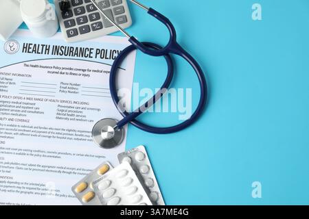 Krankenversicherung, Stethoskop, Pillen und Rechner auf hellblauem Hintergrund, flache Lay. Leerzeichen für Text Stockfoto
