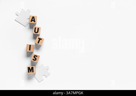 WORTAUTISMUS aus Holzwürfeln und Puzzleteilen auf weißem Hintergrund Stockfoto